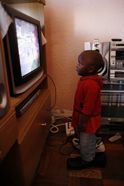 Two year old Calvin Hilimana stands and watches TV at the family home in Parrow. Calvin's father, Arcade, is a professional football player from Burundi who came to South Africa after fleeing violence...