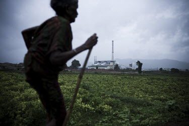An elderly woman walks in front of Vedanta Alumina plant in Lanjigarh. The huge bauxite deposits in the Niyamgiri hills have led the Vedanta group to set up an alumina refinery at Lanjigarh, making th...