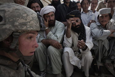 A US civilian DOD contractor (left) interviews village elders as part of a Human Terrain Team exercise whilst attached to the US Army 4th Platoon, Delta Company, 501st Airborne in Mohammed Khill.