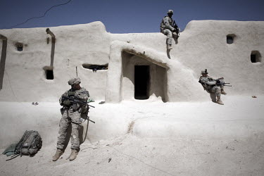 US Army soldiers from 1st Platoon, Baker Company, 3rd Battalion, 509th Infantry Airborne rest while a compound is raided during an air assault operation to search for an IED (improvised explosive devi...