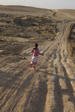 A girl from the Abu Quaider family runs out of the unrecognised village of Al Zarnock in the Negev desert. Around 75,000 Bedouin people who live in this region are in unrecognised villages. The villag...