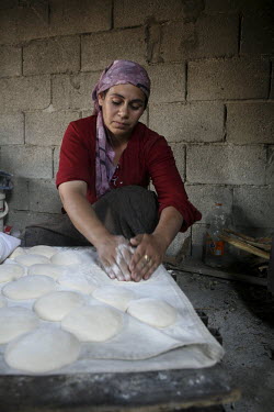 A woman makes bread at home in the unrecognised Bedouin village of Al Zarnock in the Negev desert. Around 75,000 Bedouin people who live in this region are in unrecognised villages. The villages are n...