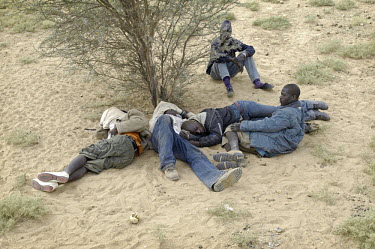 Migrants rest during a stop on their way through the desert towards the border with Algeria, to try to get to Europe in search of a better life.