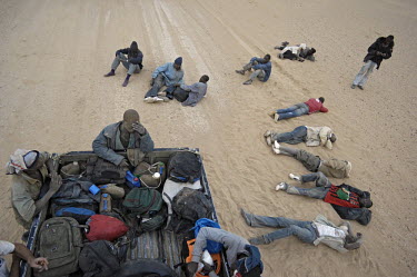Migrants relax during a stop on their way through the desert towards the border with Algeria, to try to get to Europe in search of a better life.