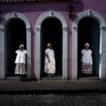 Three Irmanas (Sisters) stand at the entrance to the seat of the Irmandade da Boa Morte (Sisterhood of the Good Death). The Sisterhood began as a bank in 1823, founded by freed slaves, to finance the...