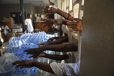People beg for water at the University Hospital five days after the earthquake hit Port-au-Prince. With logistical problems and much of the country's infrastructure having been destroyed, aid was not...
