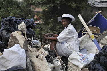 A woman dressed in pristine white clothes sits on the rubble of her house, which collapsed when an earthquake hit the country one week earlier.A 7.0 magnitude earthquake struck Haiti on 12/01/2010. Ea...