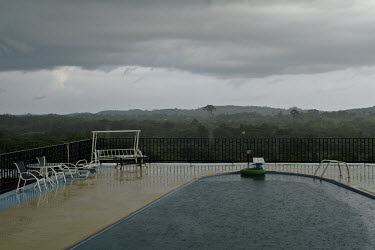 Rain falling into the swimming pool at a dilapidated ranch owned by one of Charles Taylor's former mistresses.