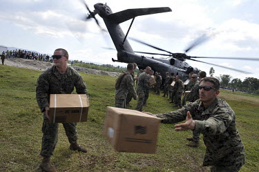 US Marines of the 22nd Marine Expeditionary Force unload food aid from a navy helicopter south west of Leogane twelve days after an earthquake hit the country. A 7.0 magnitude earthquake struck Haiti...