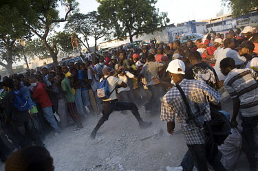 A policeman tries to regain control over an unruly crowd waiting for food aid distribution in the Delmas area of the city, ten days after an earthquake hit the country. A 7.0 magnitude earthquake stru...