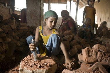Eight year old Lima works breaking up brick and stone into ballast to be used in concrete. Many children are employed in this work, earning between 25-50 Euro cents a day.