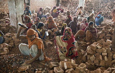 Women and children work breaking up brick and stone into ballast to be used in concrete. Many children are employed in this work, earning between 25-50 Euro cents a day.