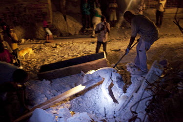 Two weeks after an earthquake hit the city, men retrieve the dead body of a relative and place it in a coffin for burial.A 7.0 magnitude earthquake struck Haiti on 12/01/2010. Early reports indicated...