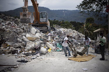Men retrieve a dead body from the rubble thirteen days after an earthquake hit the country. A 7.0 magnitude earthquake struck Haiti on 12/01/2010. Early reports indicated that more than 100,000 may ha...