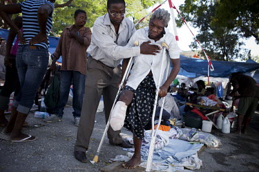 A doctor working with the NGO Handicap International supporting a woman whose leg was amputated as she tries to walk on crutches. She was injured when an earthquake hit the country. A 7.0 magnitude ea...
