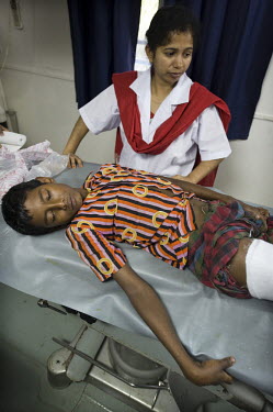 Zahid, an 11 year old boy who broke his leg falling out of a palm tree, is treated by a nurse at the Shapla hospital; a floating clinic for island residents in the delta region of southern Bangladesh....
