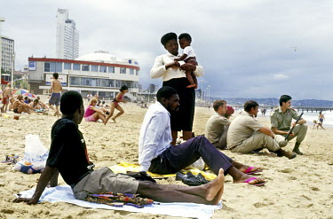 Beaches open to all, black and white. AWB members (Afrikar Weerstandsbeweging) (Afrikaner Resistance Movement) - sit on the beach near a black family after a demonstration in the city.