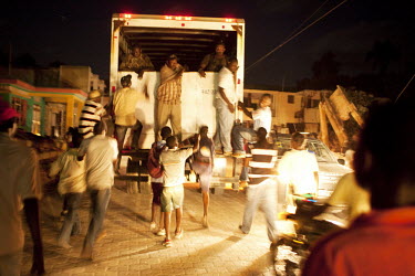 A truck transporting food aid is scaled before reaching its destination by desperate people in Leogane, near the epicentre of the earthquake that struck sixteen days earlier. The truck did not have a...