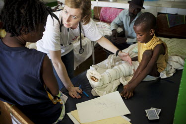 A Medecins Sans Frontieres (MSF) doctor is using a drawing to explain to a boy and his mother that the boy needs to have the lower part of his leg amputated. Here in Chancerelle hospital MSF are treat...