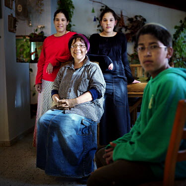 Dina Rajamin (originally from Mexico) sits with her family in the Jewish settlement of Eli.