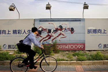 A man cycles past the Olympic Park construction site in Beijing. The city hosted the 2008 Olympic Games.