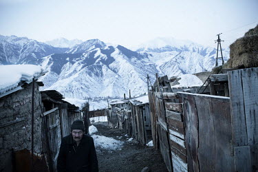 A man walks between wooden sheds in Min Kush. During the 1960s and 70s, Min-Kush was a prosperous city living off the wealth of uranium mining. It is now an impoverished and semi-deserted village of 2...