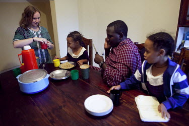 Gemma Enolengila eats breakfast with her husband Lesikar Olengila and daughters Lucia Ene-Lesikar, left and Suzie Ene-Lesikar at their home in Arusha. Gemma, who is British, worked with Lesikar (who i...