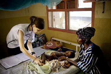 An MSF (Medecins sans Frontieres) doctor treats a child suffering with a skin disease in MSF Gondama hospital in Bo.