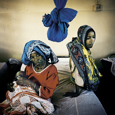 A baby suffering from malaria with his grandmother and mother in a hospital on Pemba Island.