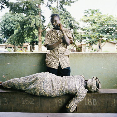In a hospital in Bujumbura, a man waits for a doctor to see his wife who is likely to have malaria.