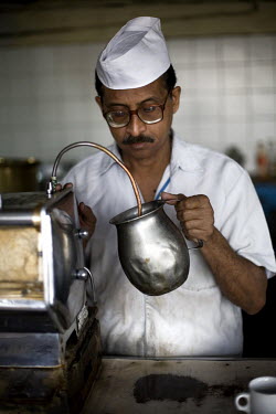 A barista warms milk for coffee from an ancient espresso machine in the Indian coffee house, Baba Kharak Singh Marg. The coffee house dates back almost fifty years, first in central Connaught Place, t...