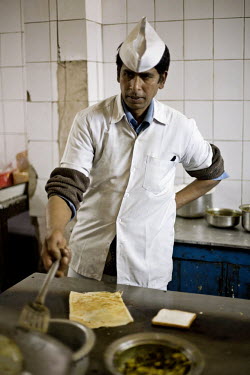 A worker making a dosa on the hotplate in the kitchen of the Indian coffee house, Baba Kharak Singh Marg. The coffee house dates back almost fifty years, first in central Connaught Place, then Janpath...