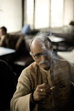 A man smoking a cigarette in the Indian Coffee House, Baba Kharak Singh Marg. The coffee house dates back almost fifty years, first in central Connaught Place, then Janpath and now at the top of a rat...