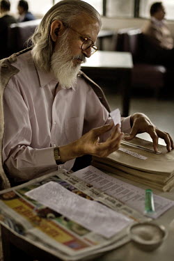A man addressing labels onto envelopes in the Indian coffee house, Baba Kharak Singh Marg. The coffee house dates back almost fifty years, first in central Connaught Place, then Janpath and now at the...