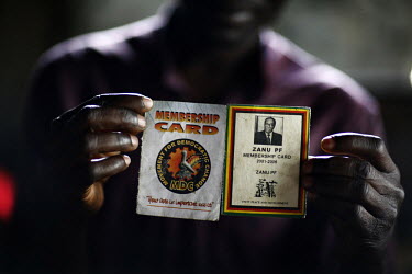 A man holds up MDC (Movement for Democratic Change) and Zanu-PF membership cards. Zanu-PF memebership was at one time required to receive food aid.