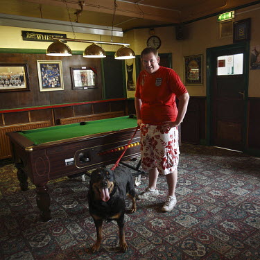 The son of the licensee, posing with his dog, at The Cross Keys pub in Paulsgrove near Portsmouth. Almost all of the patrons of the pub are local people who know each other well and meet at the pub ev...