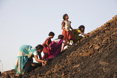 Women from the village of Kujama collect coal from the overburden dump for a nearby open pit coal mine. Overburden is the fertile soil (formerly used for agriculture) that has to be removed to get at...