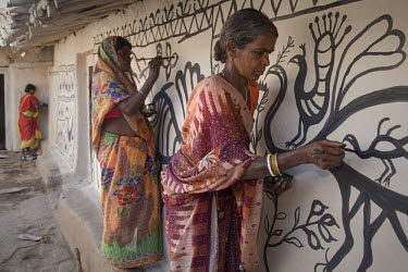 Female tribal artists decorating a courtyard in the village of Jorakath in preparation for a wedding ceremony. The painting traditions of Khovar (for weddings) and Sohrai (for harvest festivals) have...