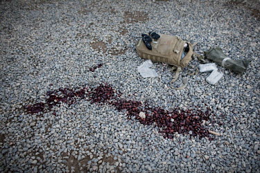 Fresh blood and a discarded medic's backpack lies on the ground where SPC Wade Slack, EOD 192D Ordnance Battalion, was hit and killed by rocket shrapnel during a Taliban attack on Jaghatu Combat Outpo...