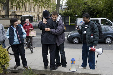 An anti-capitalist protester hugs a policeman on College Green outside the Houses of Parliament in Westminster, London.