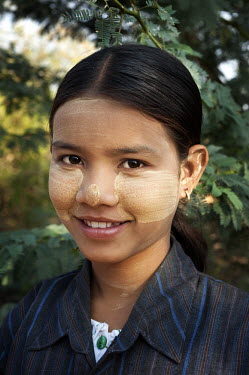 A portrait of a girl wearing tanaka, a natural sun-block made from the bark and wood of a tanaka tree.