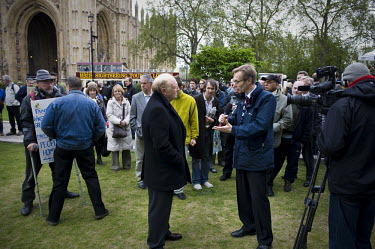 Former leader of the Labour Party Lord Neil Kinnock is interviewed for a television broadcast as a sightseeing tour bus drives past College Green in front of the Houses of Parliament in Westminster, L...