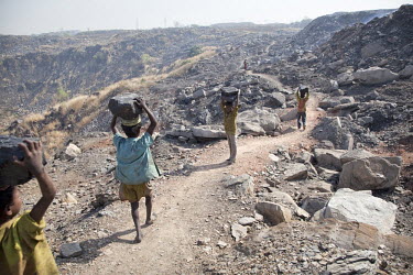 Boys carry large lumps of coal that they have scavenged from an open pit mine near Dhanbhad. They will carry this coal several kilometres to sell in a local market. As mining has displaced agriculture...