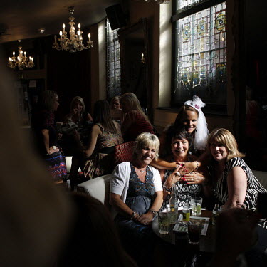 A group of women celebrating a 'hen night', a pre-wedding women-only celebration, in the Font pub in the seaside town of Brighton. The bride-to-be wears a novelty hat for the night.
