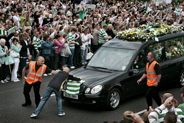 Thousands of people stand outside Celtic Park to pay their respects to the late Tommy Burns, player, manager and coach at Celtic Football Club in Glasgow. He died from cancer aged 51. A fan runs in fr...