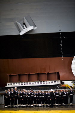 Navy cadets stand next to a large ship in the shipyard in Govan, Glasgow on the River Clyde.