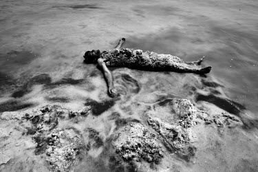 A man uses mineral rich black mud and salt to treat his skin at Lake Urmia, a salt lake in the province of West Azerbaijan. The salt and mineral laden mud are reputed to have healing properties for sk...