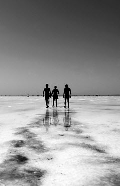 Men walk around using mineral rich black mud to treat their skin at Lake Urmia, a salt lake in the province of West Azerbaijan. The salt and mineral laden mud are reputed to have healing properties fo...