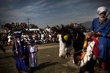 A man holding a lance rides an ornately decorated horse at the Hola Mohalla Festival. It takes place on the first day of the lunar month of Chet (March/April).