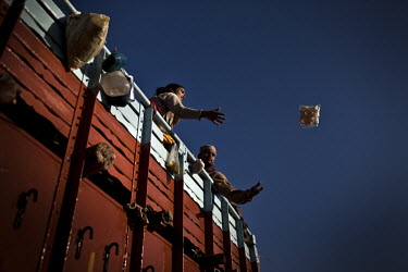 People on top of a truck recieve gifts from below during the Hola Mohalla Festival. It takes place on the first day of the lunar month of Chet (March/April).